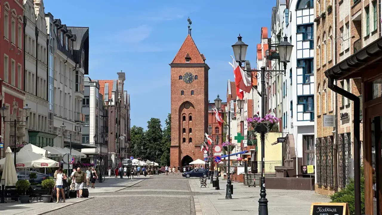 Spacer po Elblągu: Rynek z Bramą Targową i kolorowymi kamieniczkami. Idealne miejsce, by poczuć atmosferę miasta i zobaczyć, co w Elblągu warto zobaczyć.