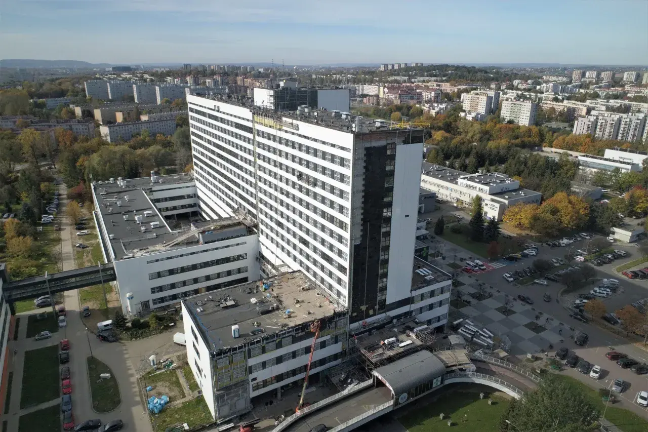 Szpital Rydygiera w Krakowie. Jak dojechać tramwajem? Widok z lotu ptaka na nowoczesny kompleks budynków szpitalnych otoczony zielenią i zabudową miejską.