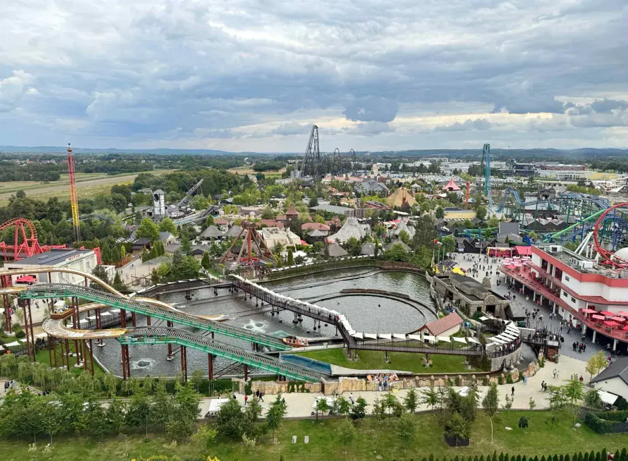 Widok na park rozrywki Energylandia w pobliżu Krakowa, z licznymi kolejkami górskimi, wodnymi atrakcjami i budynkami.