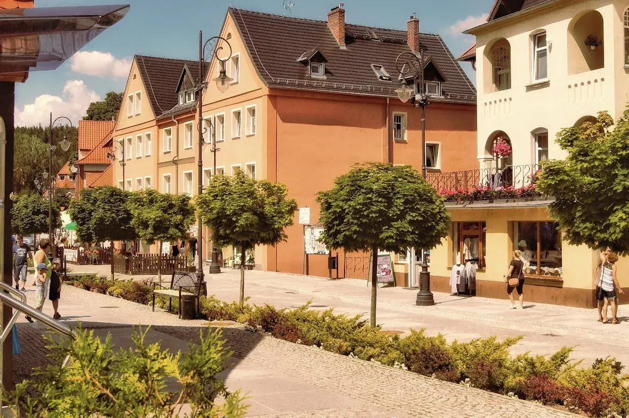 Spacerkiem po urokliwym deptaku w Świeradowie-Zdroju, gdzie kamienice i zielone drzewka tworzą atmosferę jak z Jeleniej Góry.