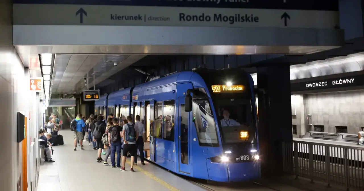 Tram 50 z Dworca Głównego w Krakowie do Prokocimia. Ludzie czekają na peronie.