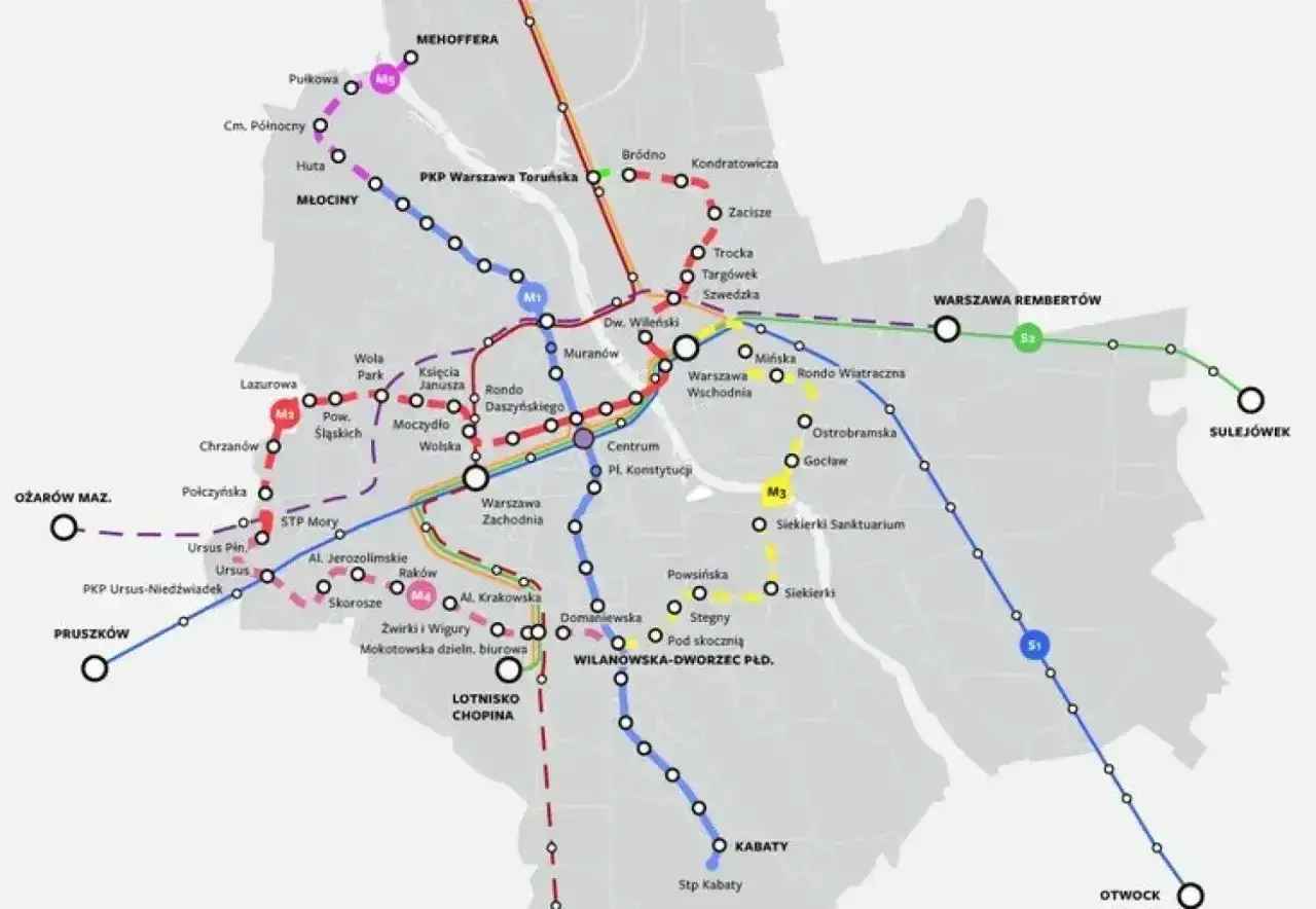 Mapa pokazuje stacje metra M2 i inne linie kolejowe w Warszawie, z zaznaczonymi węzłami przesiadkowymi i nazwami przystanków.