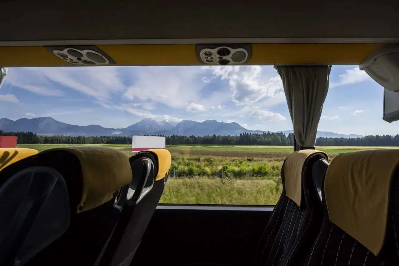 Widok z okna autobusu ze Słowenii na góry i pola.