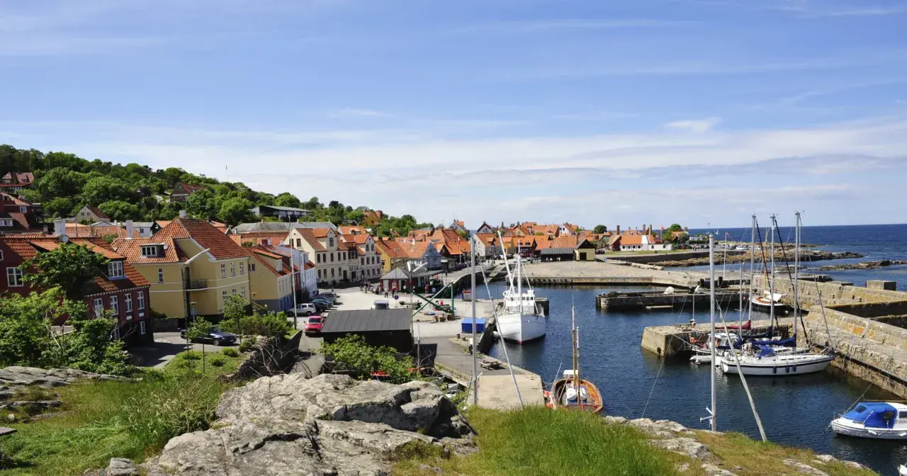Malowniczy port na Bornholmie, z kolorowymi domkami i żaglówkami. Wyobraź sobie podróż z Świnoujścia na tę duńską wyspę.