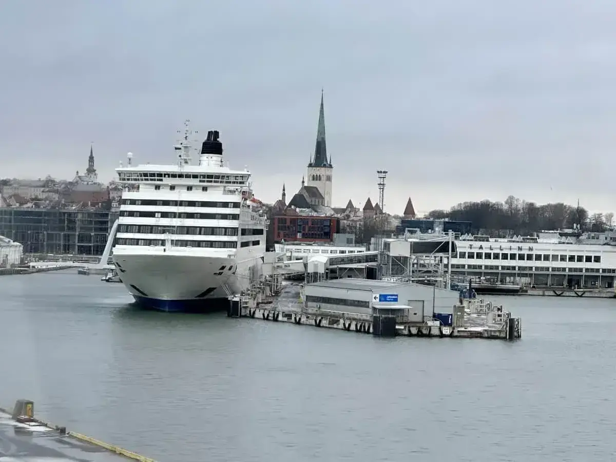 Prom Tallin Helsinki cena: duży prom pasażerski przycumowany w porcie, w tle zabytkowe budynki Tallina.