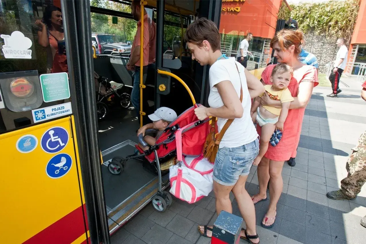 Kobiety z dziećmi wsiadają do autobusu.