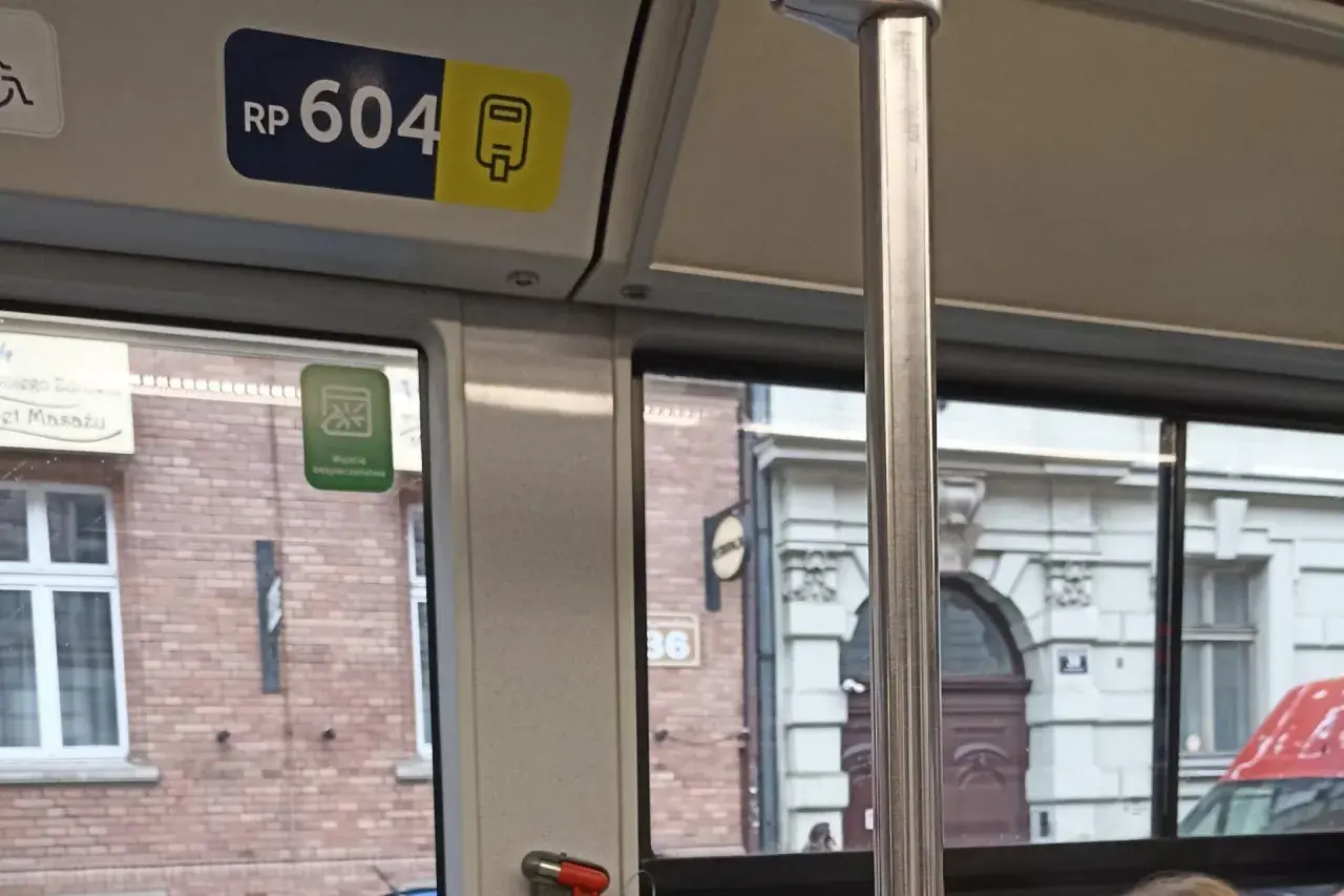 Numer boczny pojazdu kraków RP 604. Widok z okna tramwaju na zabytkową kamienicę.