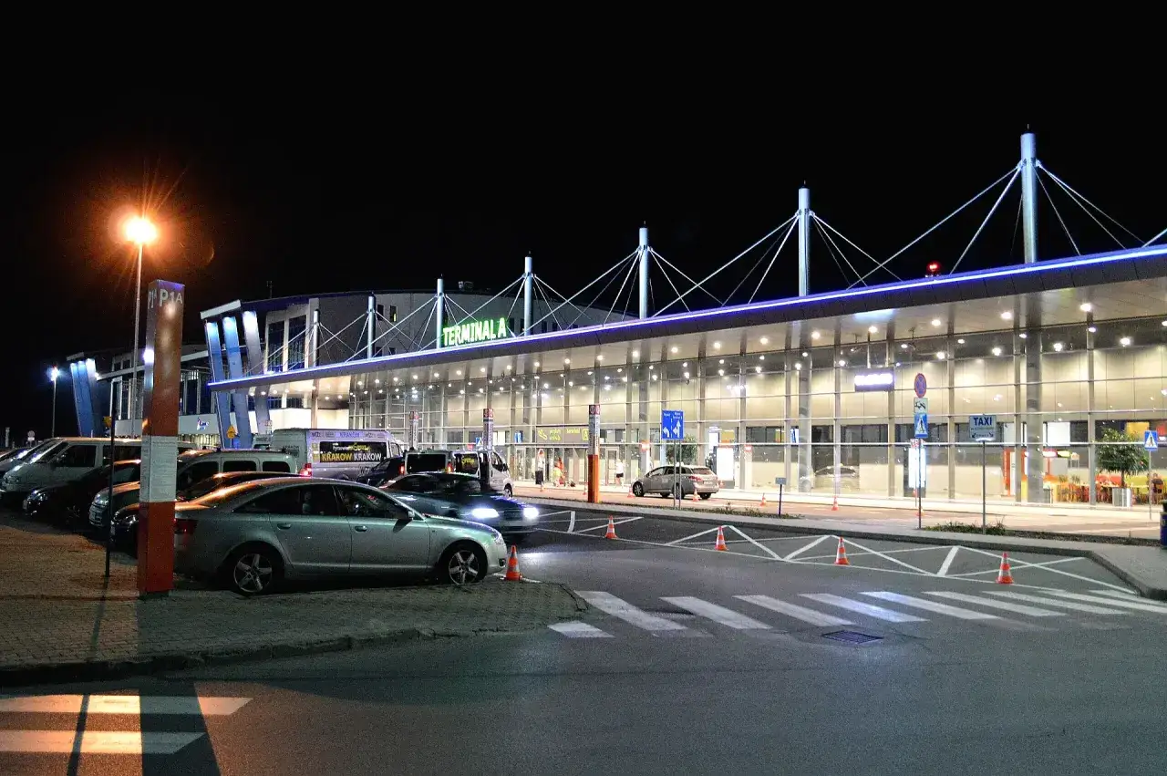 Nocne lotnisko w Rzeszowie, Terminal A, z samochodami i autokarami.