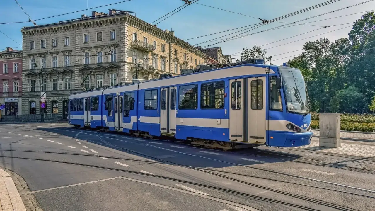 Krakowski tramwaj z niebiesko-białymi pasami, idealny na rodzinny weekend w Krakowie.