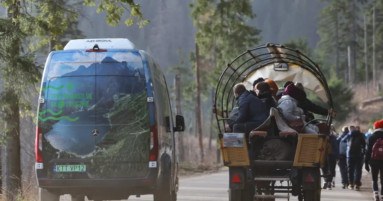 Bus z widokiem na Morskie Oko w Tatrach, obok bryczka z turystami.