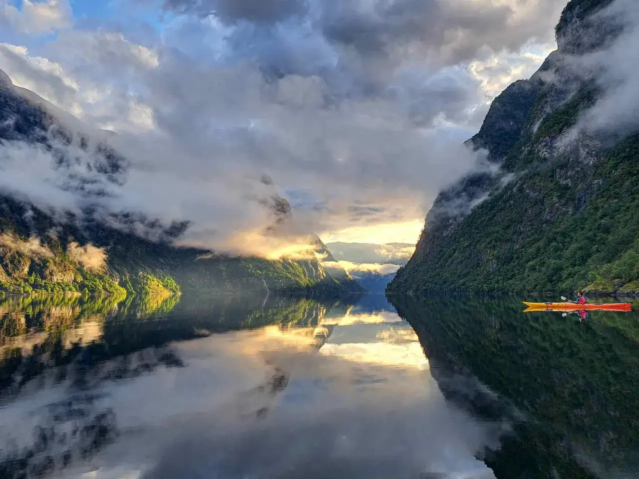 Wiosłowanie kajakiem po norweskim fiordzie o wschodzie słońca. Idealny moment, by poczuć magię natury, kiedy najlepiej jechać do Norwegii.