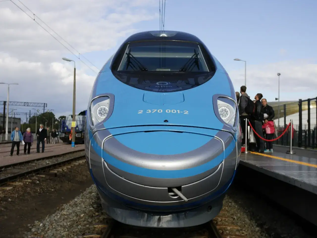 Błękitny pociąg Pendolino z szarymi pasami na froncie, gotowy do podróży. Sprawdź zniżki na Pendolino!