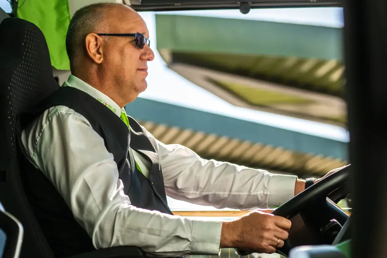 Kierowca Flixbus w okularach przeciwsłonecznych prowadzi autobus. Czy można kupić bilet u kierowcy? Zapytaj go!
