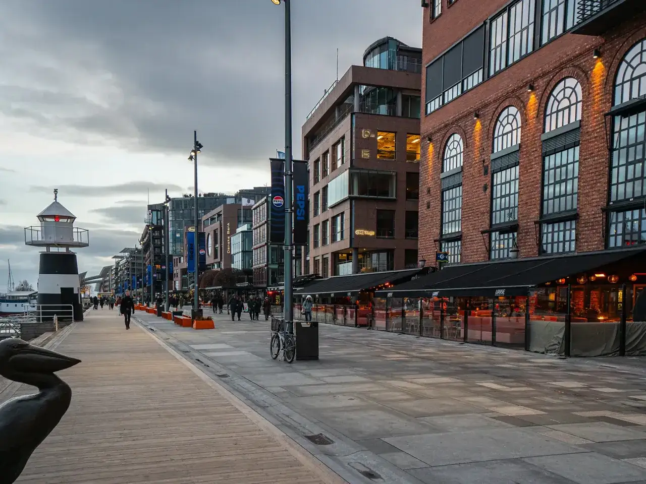 Spacerem po nabrzeżu w centrum Oslo, z latarnią morską i kawiarniami.