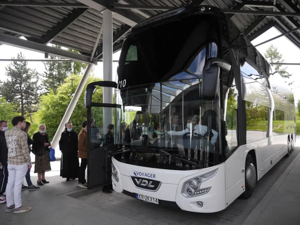 Grupa osób czeka na autobus Kołobrzeg - Ustronie Morskie. Sprawdź cenę przejazdu.