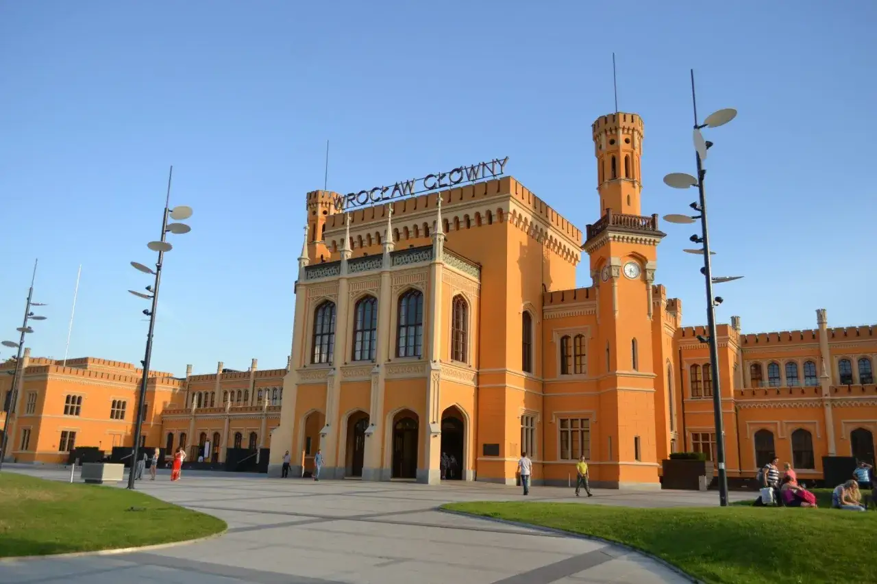 Wrocław Główny - stąd łatwo dojść na rynek. Pomarańczowy dworzec kolejowy z wieżami i zegarem.