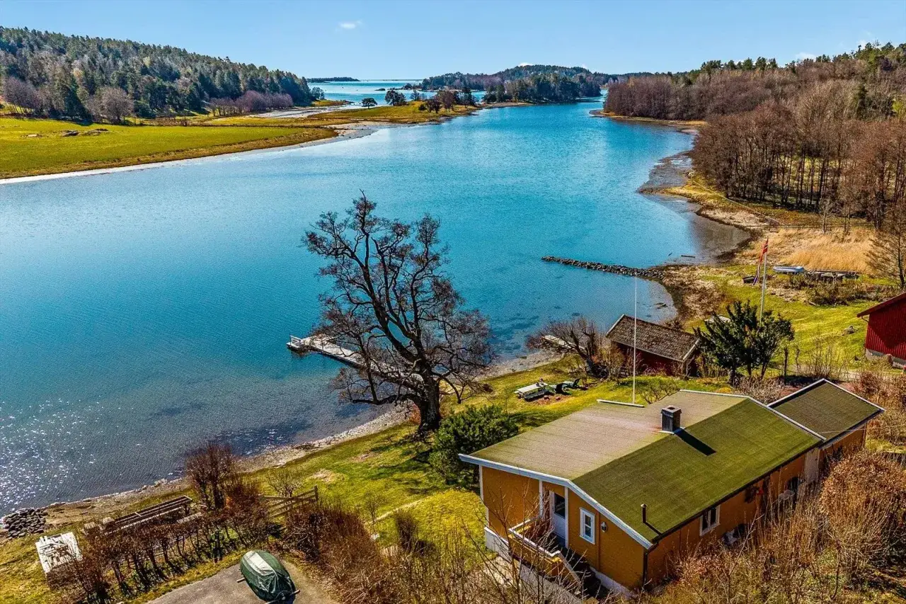 Malownicze sandefjord fiordy z domkami nad wodą, zielonymi łąkami i lasem.